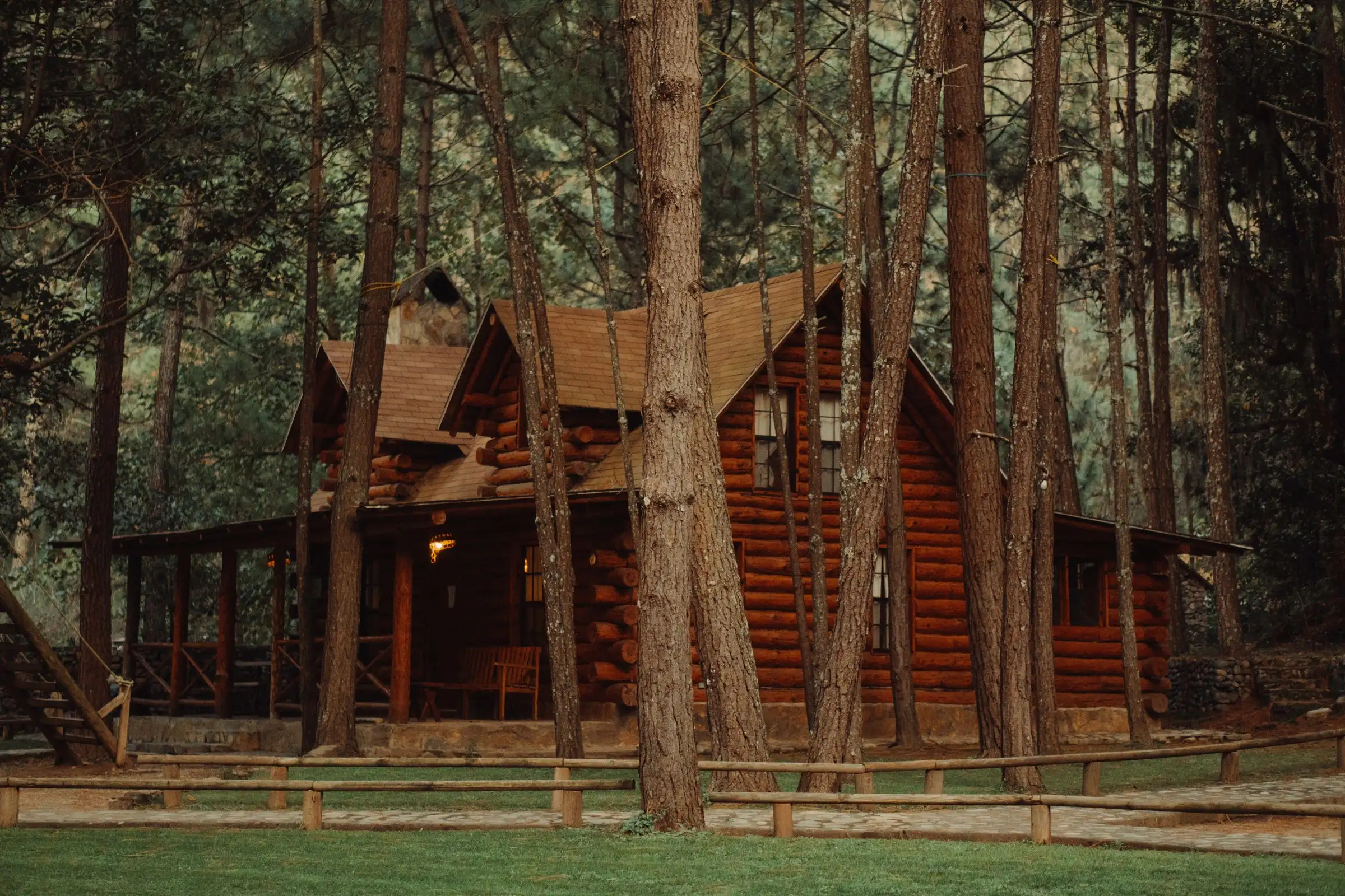 Casa grande de madera con dos techos entre pinos altos