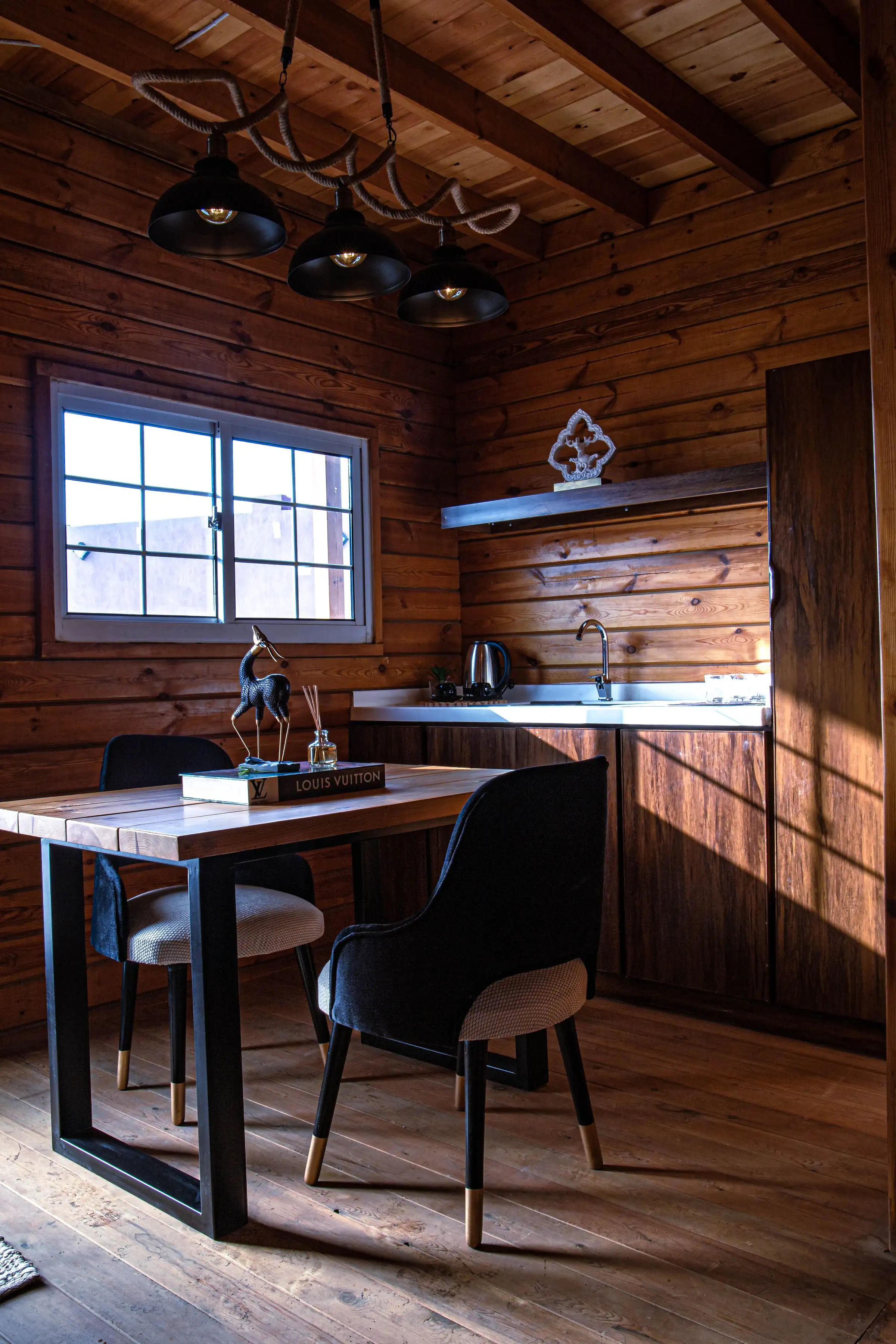 Cocineta con mesa y dos sillas junto a una ventana